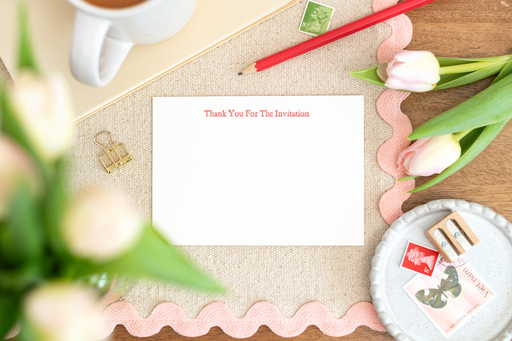 Letterpress A6 Note card with the text 'Thank you for the invitation'. The Card sits on a table with flowers, stationery and a cup of tea