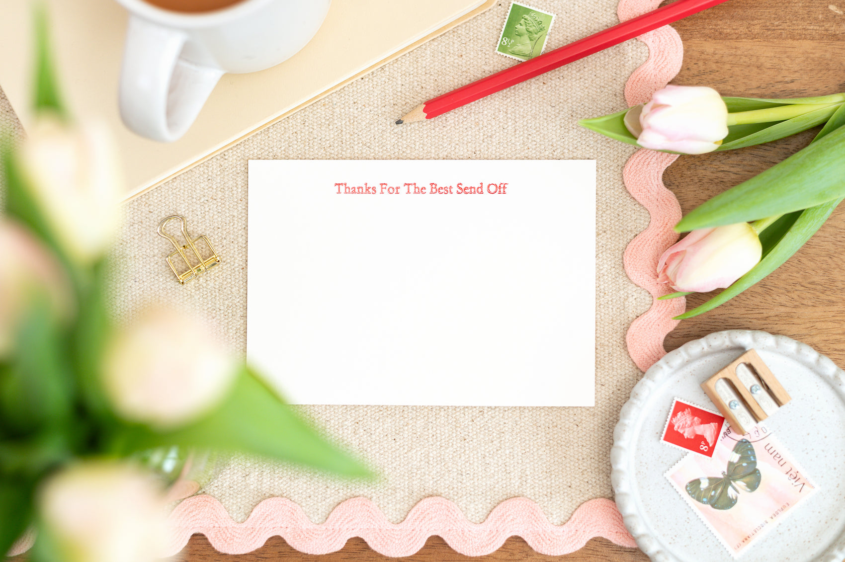 Letterpress Card with the text  'Thanks For The Best Send Off' on a desk with flowers, mug, and stationery.
